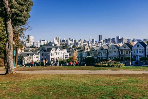 White And Gray Concrete Building Near Green Trees Under Blue Sky During Daytime
