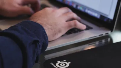 Close-Up Of Hands Typing On A Laptop In A Tech Environment.