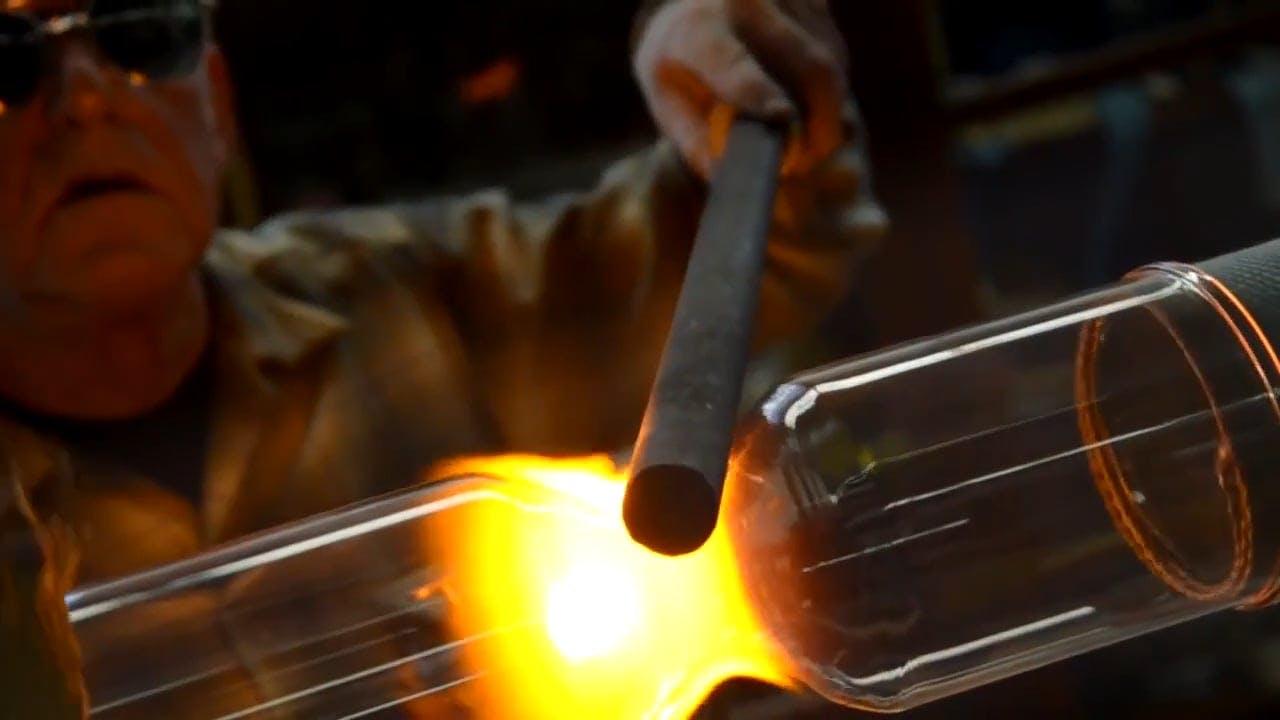 Captivating Display Of Glassblowing Techniques In An Industrial Environment.